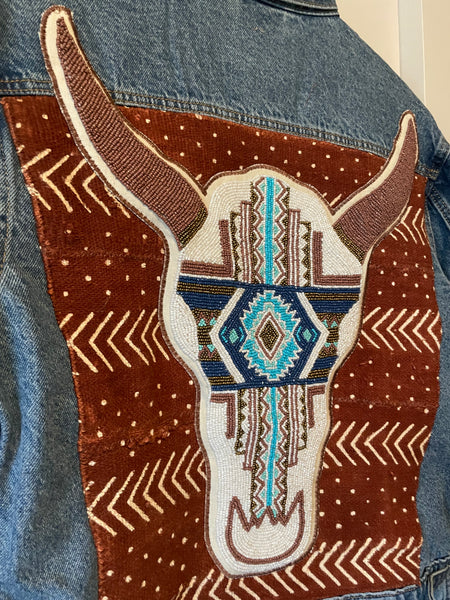 Denim jacket with added hand beaded blue Southwest cow skull on African Mud cloth